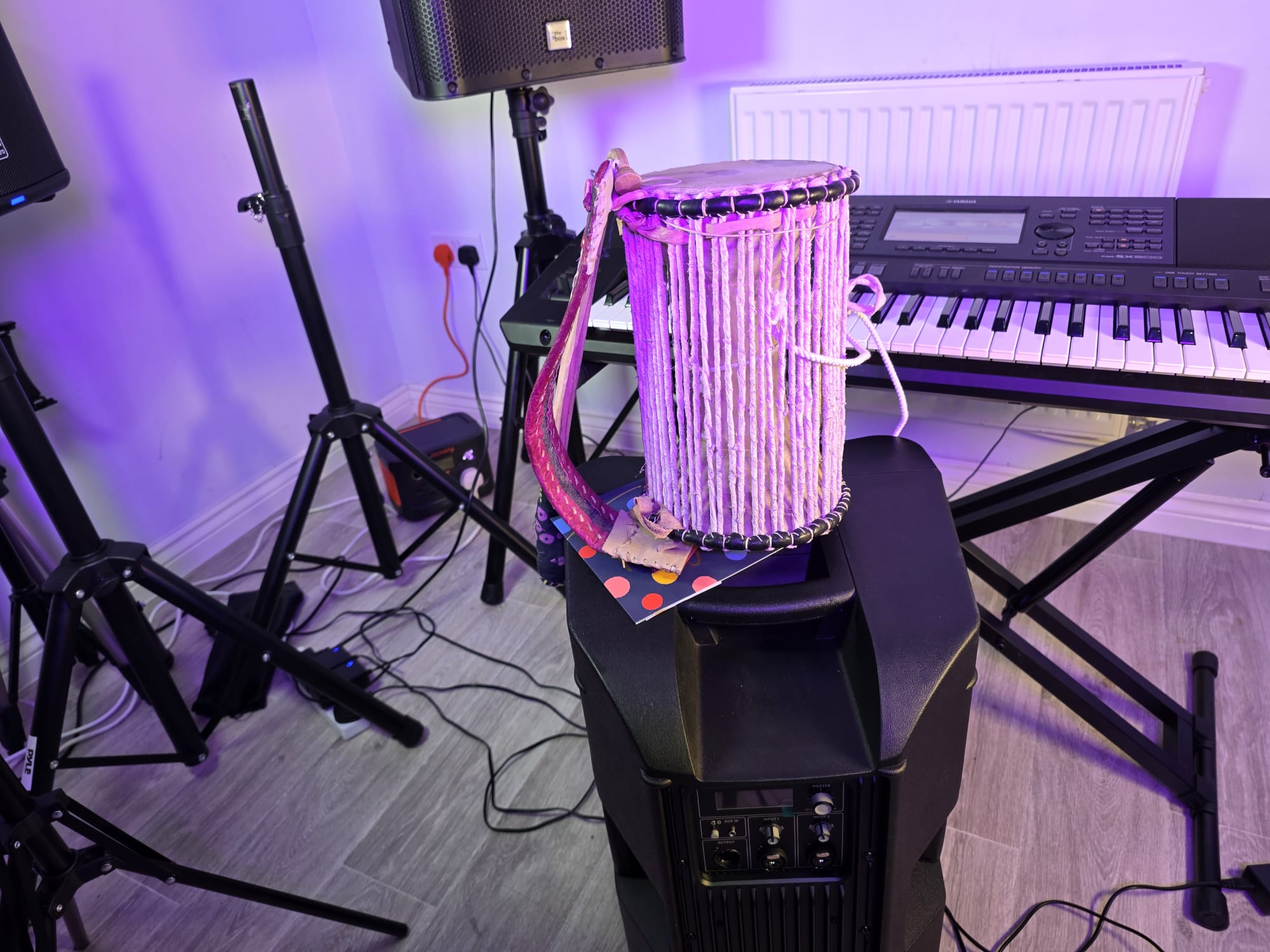 Traditional drum, keyboard, and speaker setup with purple lighting
