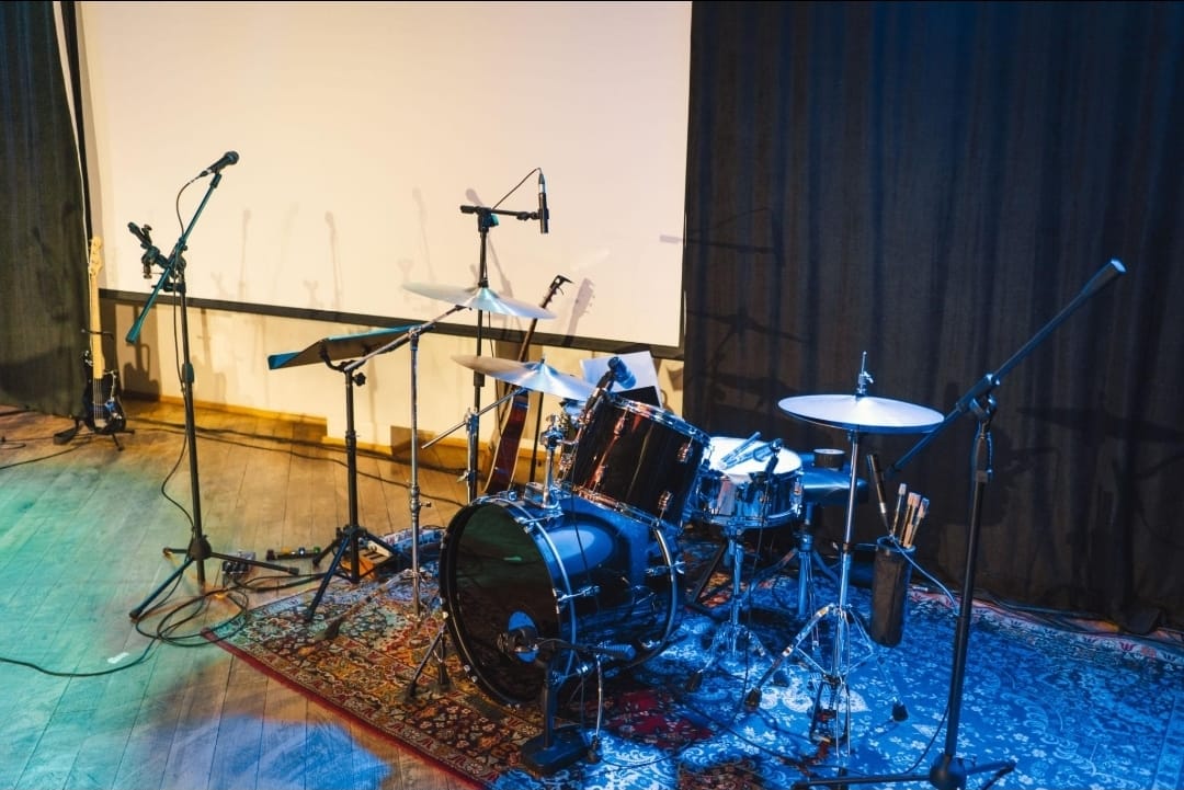 Drum kit with microphones set up on stage for a live performance